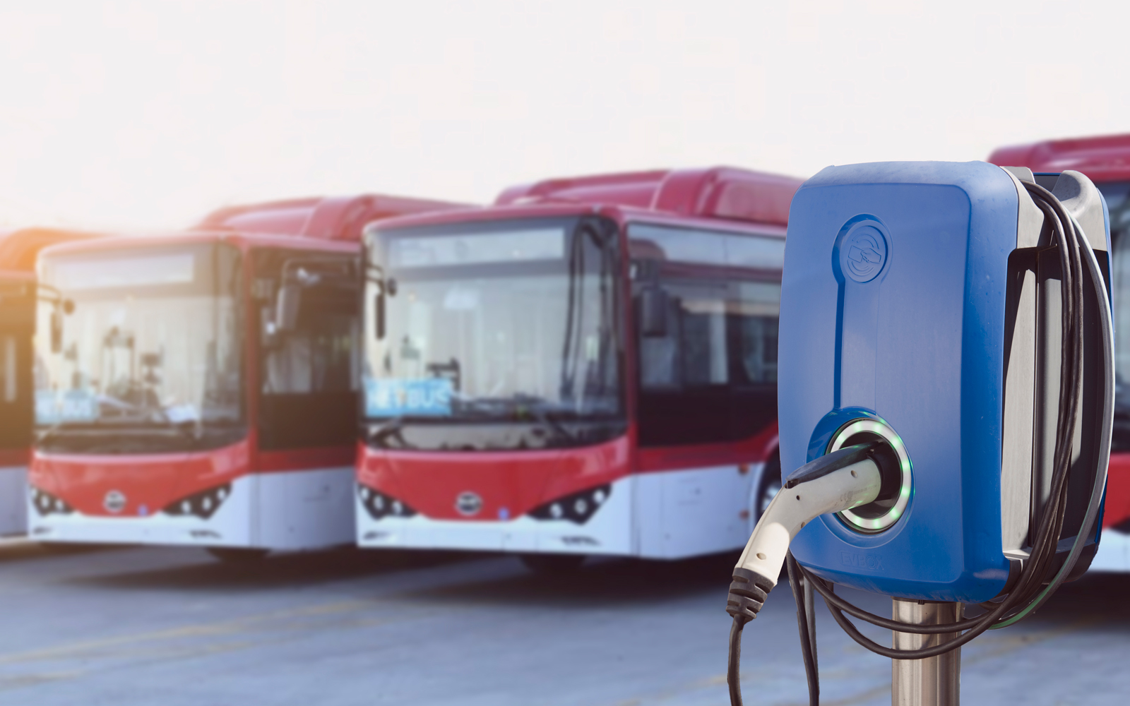 Electric vehicle charging station in front of bus fleet