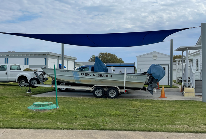 Photo of a US EPA Research boat on a trailer under a shaded area