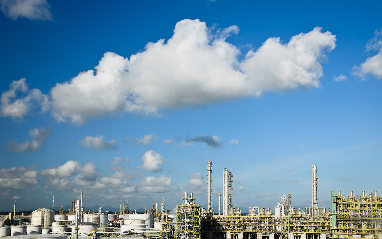 Petrochemical plant below a blue sky with clouds