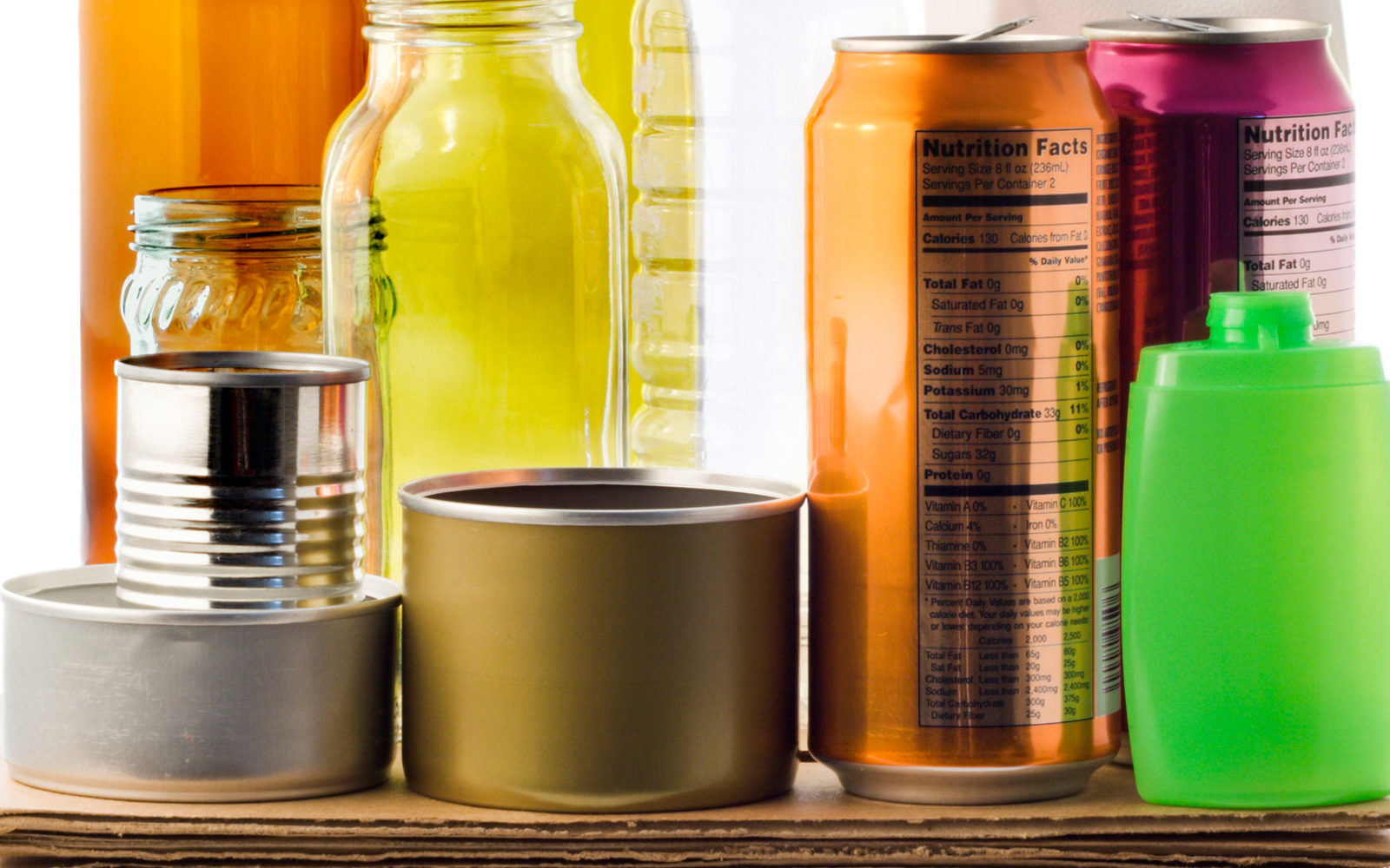 A colorful variety of different packaging types, including cans, glass jars, plastic bottles, and cardboard