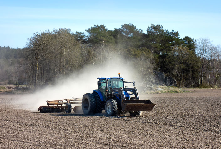 Photo of a diesel powered tractor grading a field
