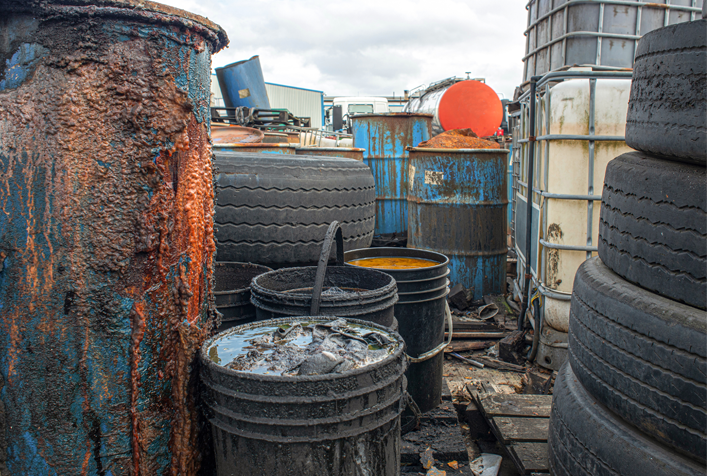 photo of hazardous waste barrels, containers, and old tires