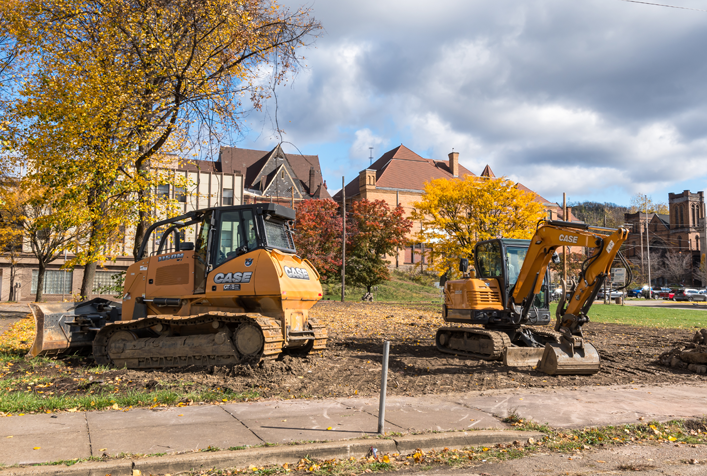 Image of bulldozer and excavating equipment near a neighborhood